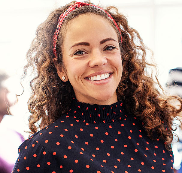 woman smiling after working with a holistic health coach to restore energy and balance